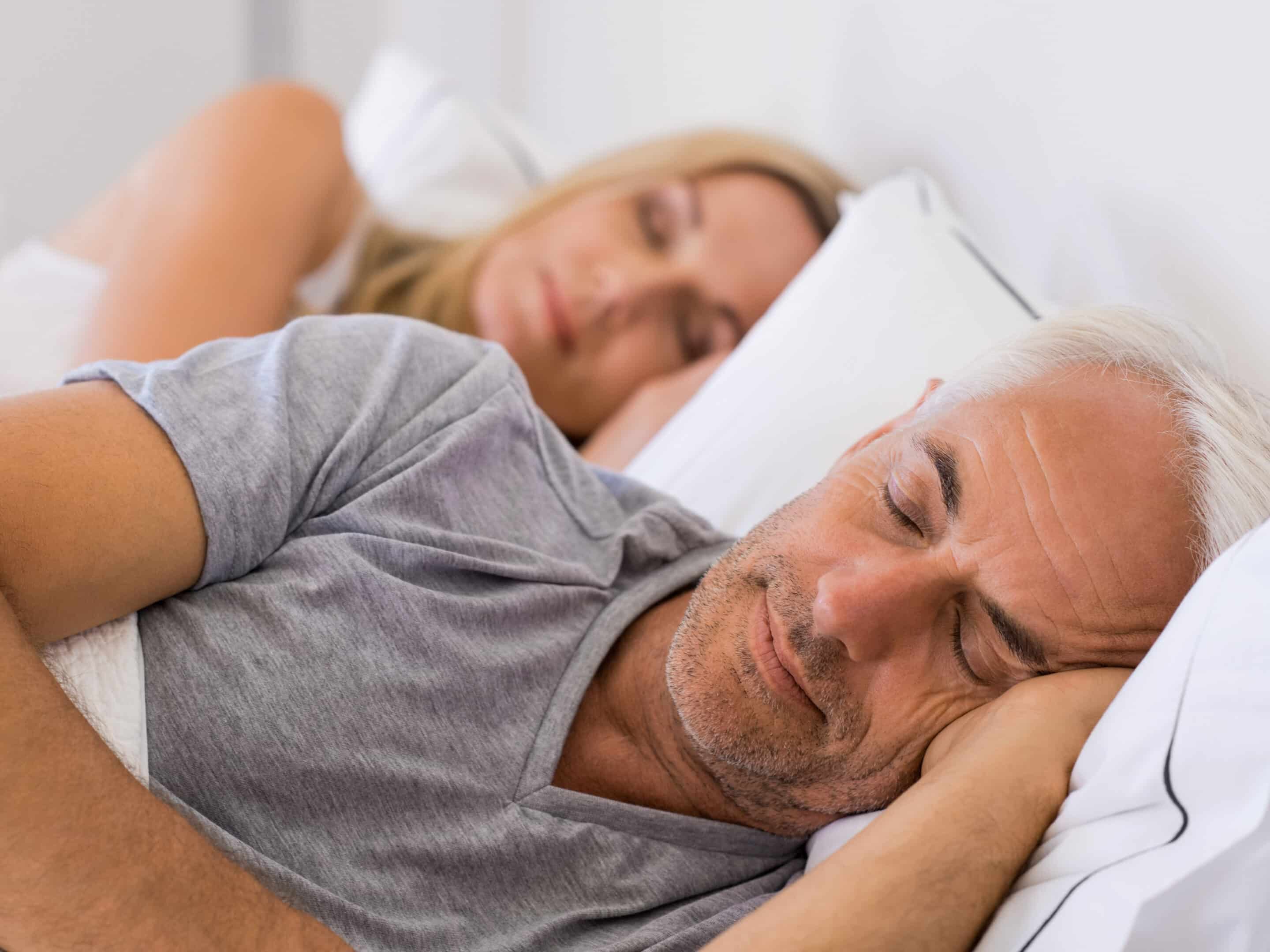 Senior man and woman sleeping. Senior man and woman resting with eyes closed. Mature couple sleeping together in their bed.